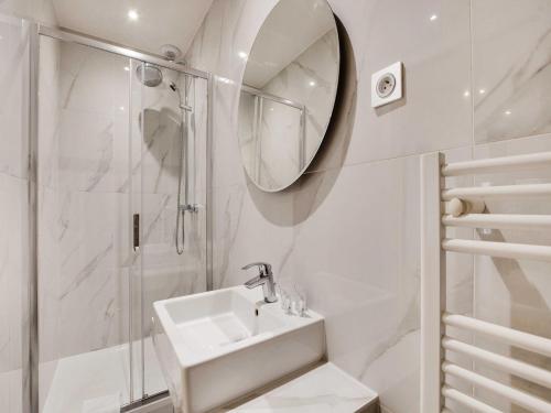 une salle de bain blanche avec un lavabo et une douche dans l'établissement Comfortable studio - 1BR 4P - République, à Paris