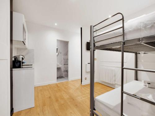Il comprend une chambre avec des lits superposés et une cuisine. dans l'établissement Comfortable studio - 1BR 4P - République, à Paris