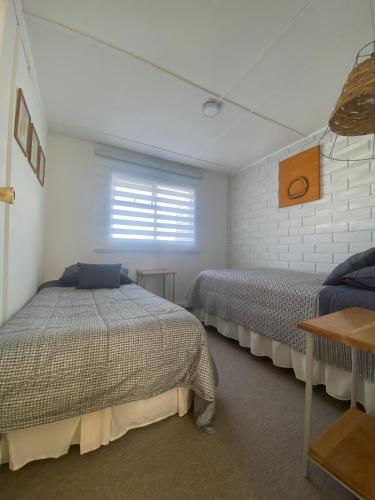 a bedroom with two beds and a window at Casa Ovejero in Punta Arenas