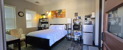 a bedroom with a white bed and a refrigerator at Guesthouse/Casita Goodyear in Goodyear