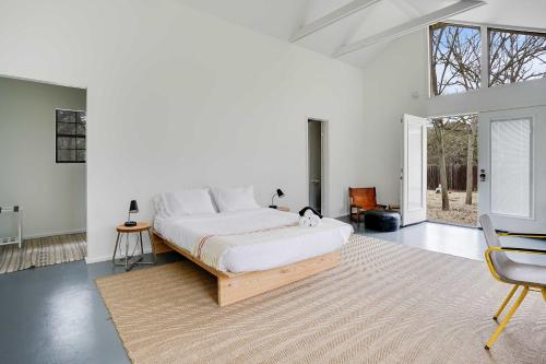 Dormitorio blanco con cama grande y alfombra en Nature Retreat - Firepit & Private Trail, en San Marcos