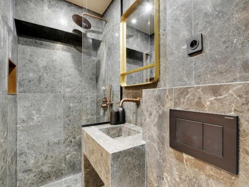 La salle de bains est pourvue d'une douche en pierre et d'un lavabo. dans l'établissement Exceptional 2BR 6P Apartment - Caire Montorgueil, à Paris