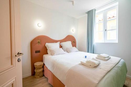 une chambre avec un grand lit avec des serviettes dessus dans l'établissement Beautiful 2bdr flat - Hyper centre St Tropez, à Saint-Tropez