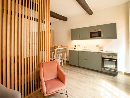 un salon avec une chaise et une cuisine dans l'établissement Chic Studio - 2P - in the heart of Saint-Tropez, à Saint-Tropez