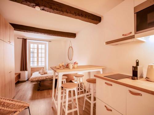 une cuisine avec une table et des tabourets dans une pièce dans l'établissement Chic Studio - 2P - in the heart of Saint-Tropez, à Saint-Tropez