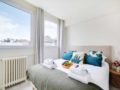 - une chambre avec un lit, des serviettes et une fenêtre dans l'établissement Modern apartment - 2BR 6P - Faubourg-du-Roule, à Paris