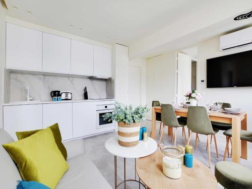 une cuisine et un salon avec une table et des chaises dans l'établissement Modern apartment - 2BR 6P - Faubourg-du-Roule, à Paris