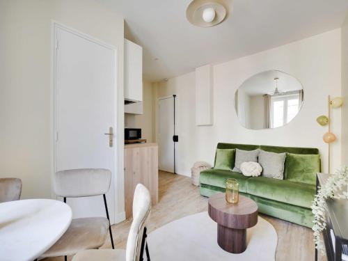 un salon avec un canapé vert et une table dans l'établissement Charming apartment - 1BDR-4P - Ivry-sur-Seine, à Ivry-sur-Seine