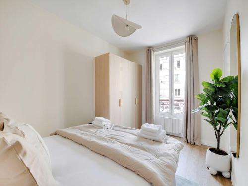 - une chambre blanche avec un grand lit et une plante en pot dans l'établissement Charming apartment - 1BDR-4P - Ivry-sur-Seine, à Ivry-sur-Seine