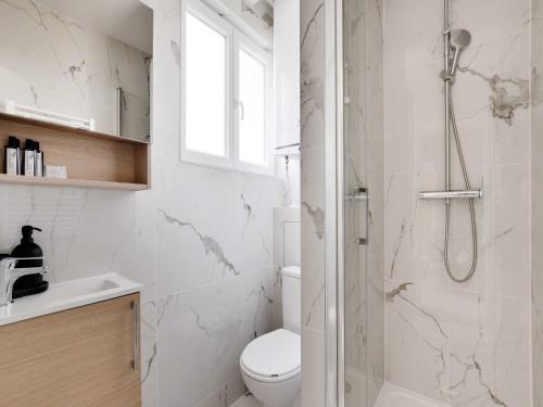 une salle de bain blanche avec douche et toilettes dans l'établissement Cosy apartment - 1BDR-4P - Ivry-sur-Seine, à Ivry-sur-Seine