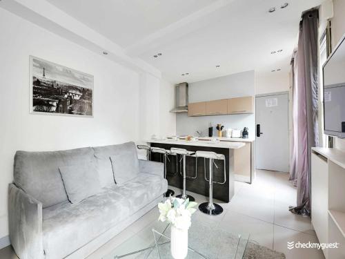 un salon avec un canapé et une cuisine dans l'établissement Cosy apartment - 1BR 4P - Europe Saint-Lazare, à Paris