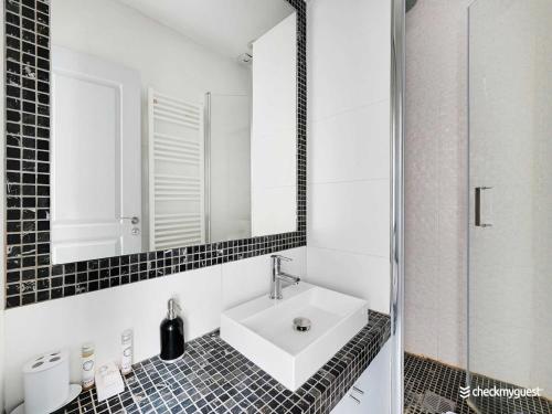 une salle de bain avec un lavabo et un miroir dans l'établissement Cosy apartment - 1BR 4P - Europe Saint-Lazare, à Paris