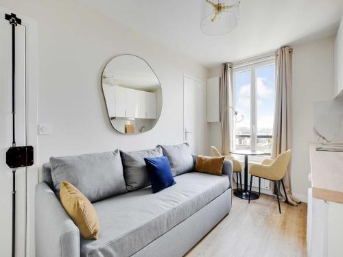 un salon avec un canapé et un miroir dans l'établissement Charming apartment - 1BDR-4P - Ivry-sur-Seine, à Ivry-sur-Seine
