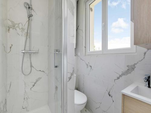 une salle de bain blanche avec douche et toilettes dans l'établissement Cosy apartment in Ivry-sur-Seine, à Ivry-sur-Seine