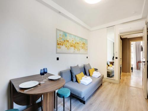 un salon avec un canapé bleu et une table dans l'établissement Beautiful apartment - 2BR 6P - Père-Lachaise, à Paris