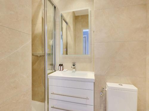 une salle de bain avec toilettes, lavabo et miroir dans l'établissement Beautiful apartment - 2BR 6P - Père-Lachaise, à Paris