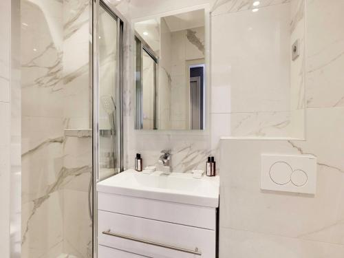 une salle de bain blanche avec un lavabo et une douche dans l'établissement Modern apartment & terrace - 2BR 6P - Near Nation, à Paris