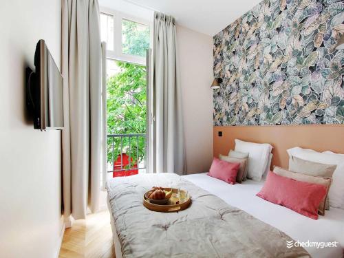 une chambre avec un lit avec un bol de fruits dessus dans l'établissement Stylish apartment - 2BR 6P - Le Marais, à Paris