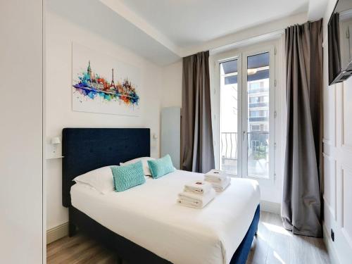 une chambre avec un grand lit avec une fenêtre dans l'établissement Modern apartment & terrace - 2BR 6P - Near Nation, à Paris