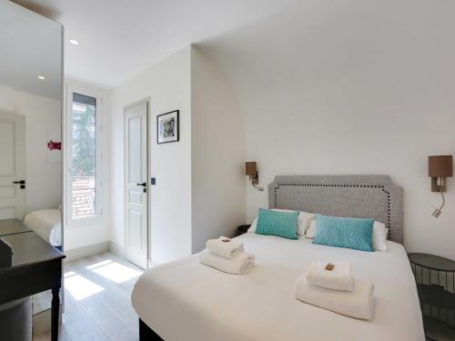 une chambre blanche avec un lit avec des serviettes dessus dans l'établissement Chic apartment - 2BR 6P - Roquette, à Paris