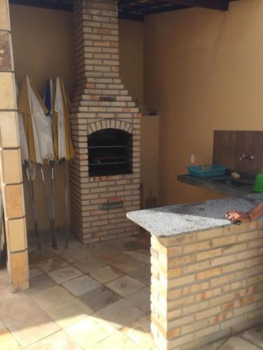 a kitchen with a brick oven in a room at Condomínio Arituba Tropical - Praia Camurupim - Apartamento a 150m da praia in Nísia Floresta