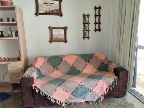 a bedroom with a bed with a plaid blanket at Condomínio Arituba Tropical - Praia Camurupim - Apartamento a 150m da praia in Nísia Floresta
