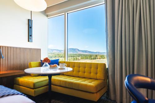 a room with a couch and a table and a window at Hotel Polaris in Colorado Springs