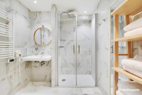 une salle de bain blanche avec une douche et un lavabo dans l'établissement Cozy apartment - 1BR 4P Montmartre Sacré C ur, à Paris