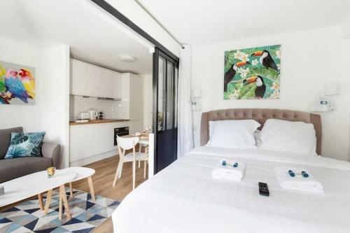 une chambre avec un grand lit blanc et une cuisine dans l'établissement Cozy apartment - 1BR 4P Montmartre Sacré C ur, à Paris