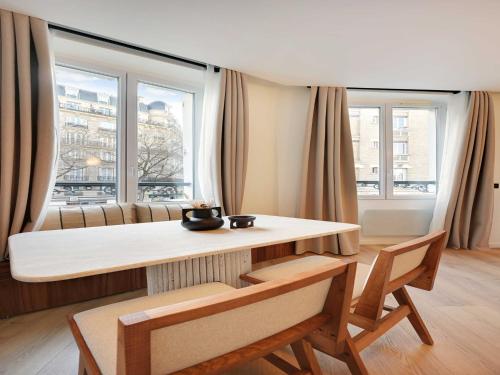 un salon avec une table, des chaises et des fenêtres dans l'établissement Elegant apartment - 1BR 4P - Sacré-C ur, à Paris