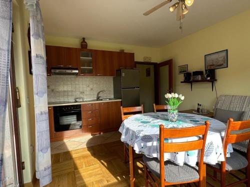 a kitchen with a table with a vase of flowers on it at Apartments with parking space Bozava, Dugi otok - 23903 in Božava