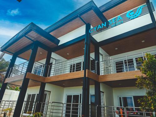 a building with a blue sign on it at Cyan Sea Suites in Bolinao