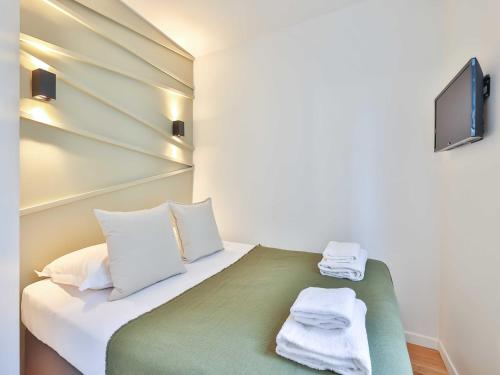 une chambre avec un lit avec des serviettes dessus dans l'établissement Amazing Apartment 1BR 4P - Crémieux - Gare de Lyon, à Paris