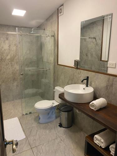 a bathroom with a toilet and a sink and a shower at Suites Ayampe Front Beach in Ayampe