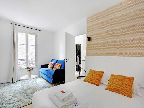 - une chambre avec un lit blanc et un canapé bleu dans l'établissement Cozy Studio - 4P - Place de la Bastille, à Paris