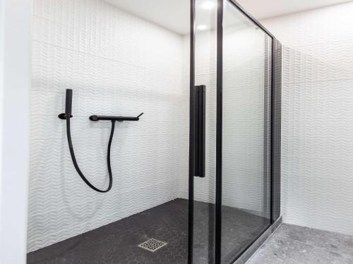 une douche avec une porte vitrée dans une salle de bain dans l'établissement Cosy Studio - Parc des expositions Tour Eiffel 5, à Paris