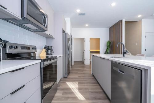 a kitchen with white counters and stainless steel appliances at Doppio Westside in Orlando