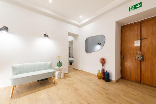 een woonkamer met een bank en een houten deur bij Ventuno Dei Luxury Suites San Giovanni in Rome