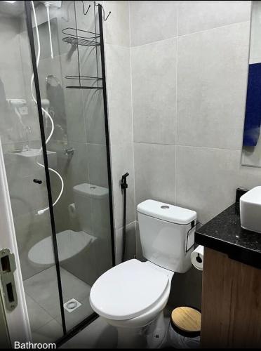 a bathroom with a toilet and a glass shower at Royal Luxury 305 in Poços de Caldas