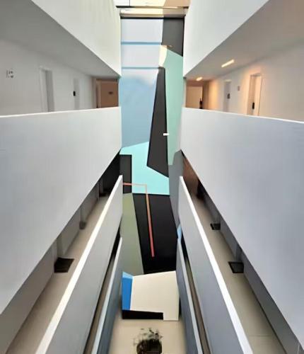 a staircase in an office building with white walls at Royal Luxury 305 in Poços de Caldas