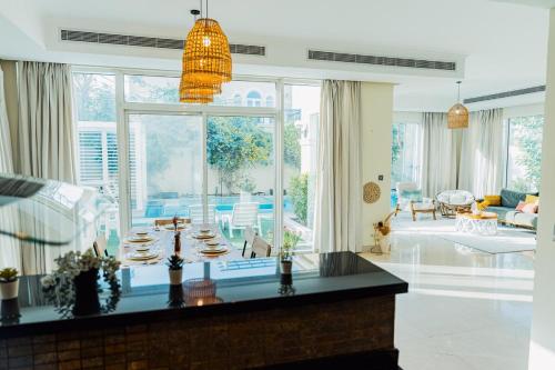 a living room with a large window and a dining room at Stunning 4BR Jumeira Park Villa With Pool and Jacuzzi in Dubai