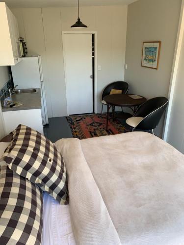 a bedroom with a bed and a table and chairs at Private Olive Grove Studio in Mangonui
