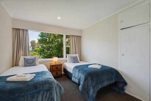 two beds in a room with a window at The BIGGEST & BEST VIEWS 3 Bedrooms WALK To Town in Queenstown