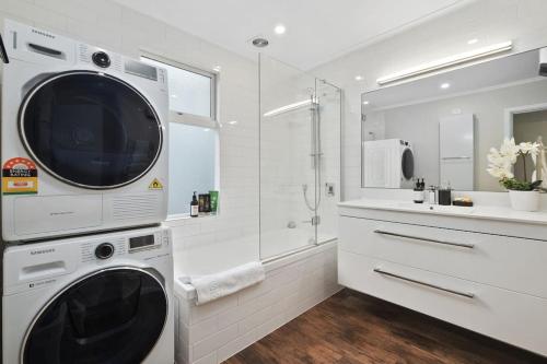 a white bathroom with a washing machine in it at The BIGGEST & BEST VIEWS 3 Bedrooms WALK To Town in Queenstown
