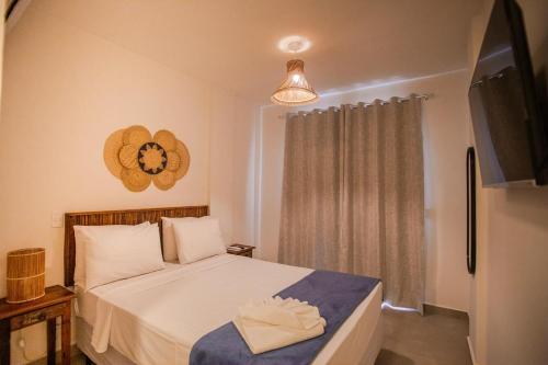 a small bedroom with a bed and a television at Casa Dela Pousada in Cabo Frio