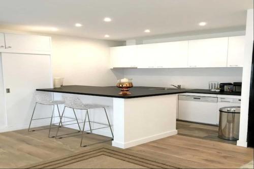 une cuisine avec des armoires blanches et un comptoir noir dans l'établissement Beautiful apartment - Galeries Lafayette, à Paris