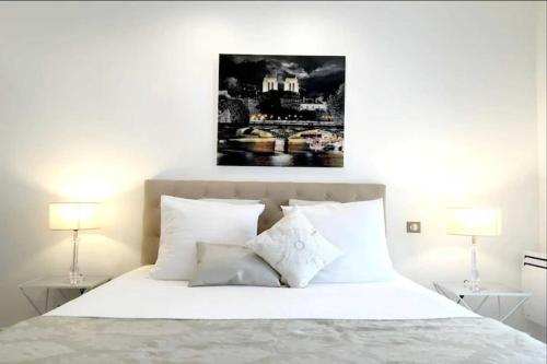 - une chambre avec un lit blanc et 2 lampes dans l'établissement Beautiful apartment - Galeries Lafayette, à Paris