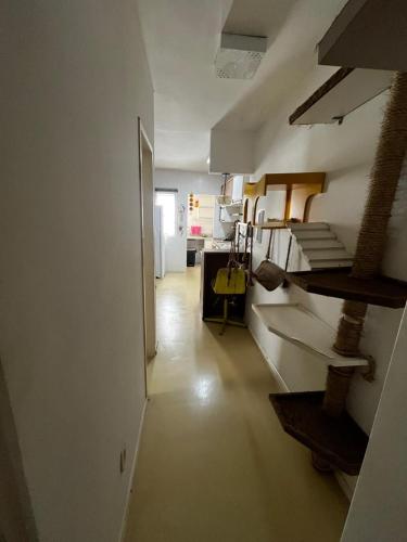 a room with a hallway with a kitchen and a stairway at A poucos passos da praia, no melhor local da Praia do Mar Grosso! in Laguna