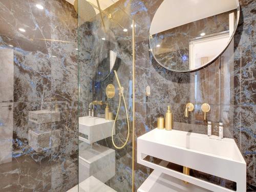 une salle de bain avec un lavabo et un miroir dans l'établissement Magnificent apartment - 2BR 4P - Place des Vosges, à Paris