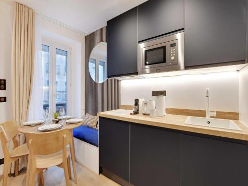 une cuisine avec un comptoir et une table avec un four micro-ondes dans l'établissement Magnificent apartment - 2BR 4P - Place des Vosges, à Paris